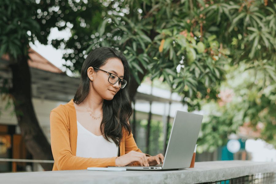 an asian woman working on her laptop