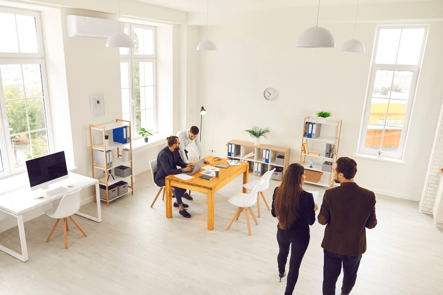 three men and one woman working in an office space