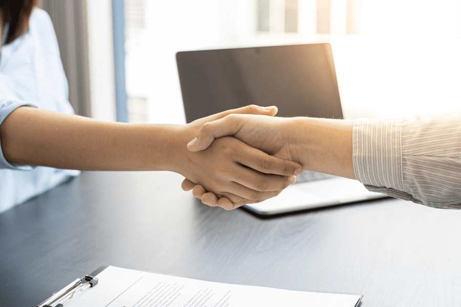 an HR manager shaking hands with an employee