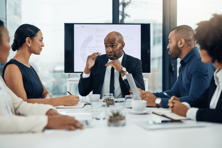 five African colleagues discussing strategy in a meeting room