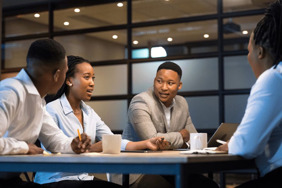 four African colleagues discussing salary benchmarking at a table