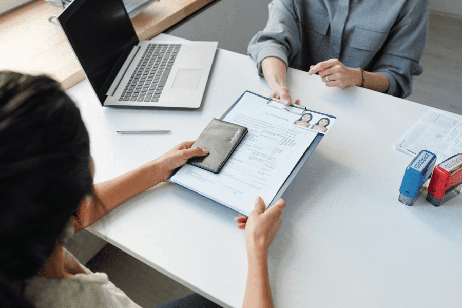 an employee handing her passport to apply for an employer-sponsored visa